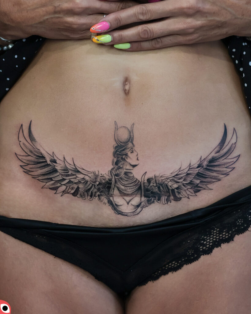 tatuaż graficzny izyda brzuch blizna skrzydła kobieta bogini egipt czarny